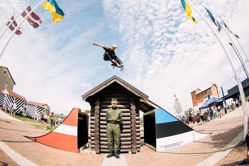 A photo showcasing a skater in the air flying over a guard at the Estonian-Latvian border